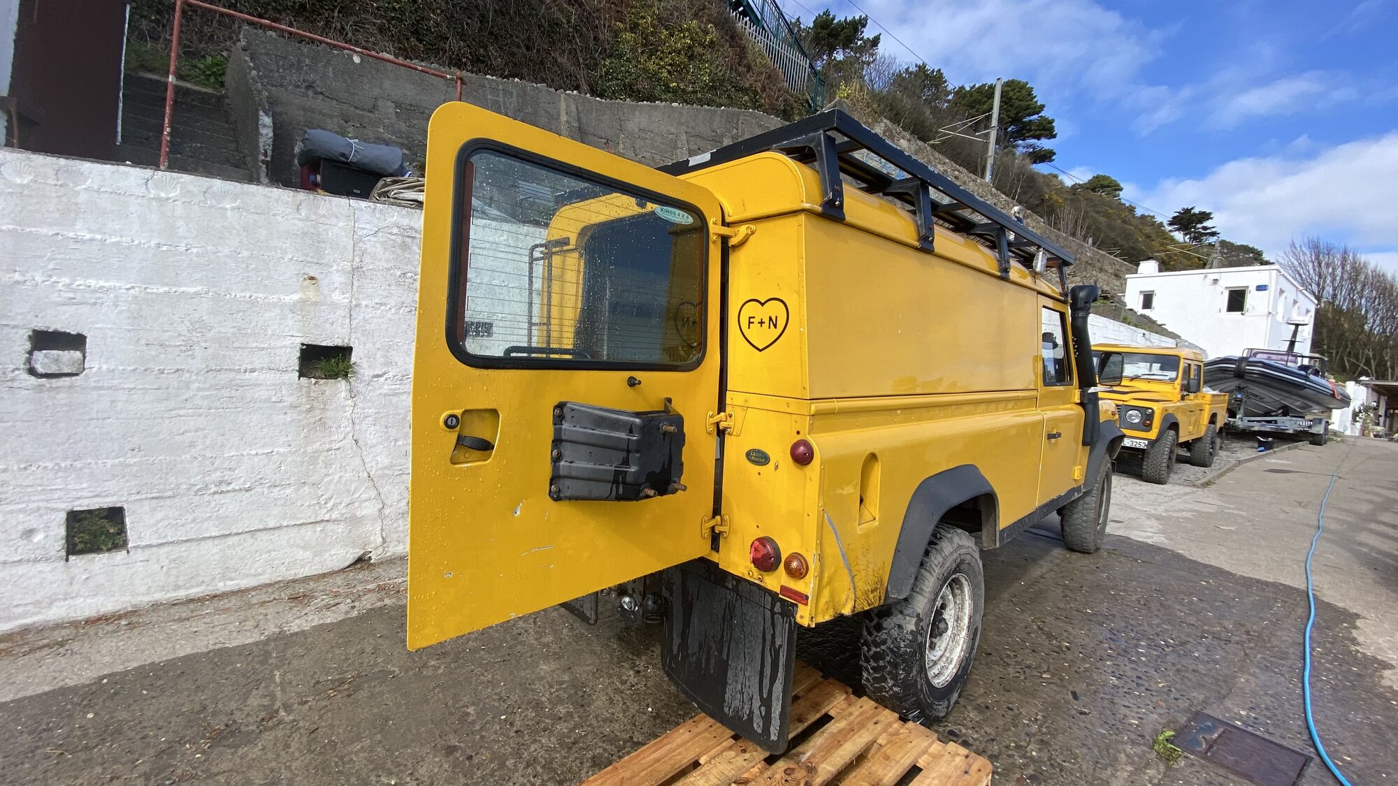 The yellow Land Rover support vehicle with F + N decal.
