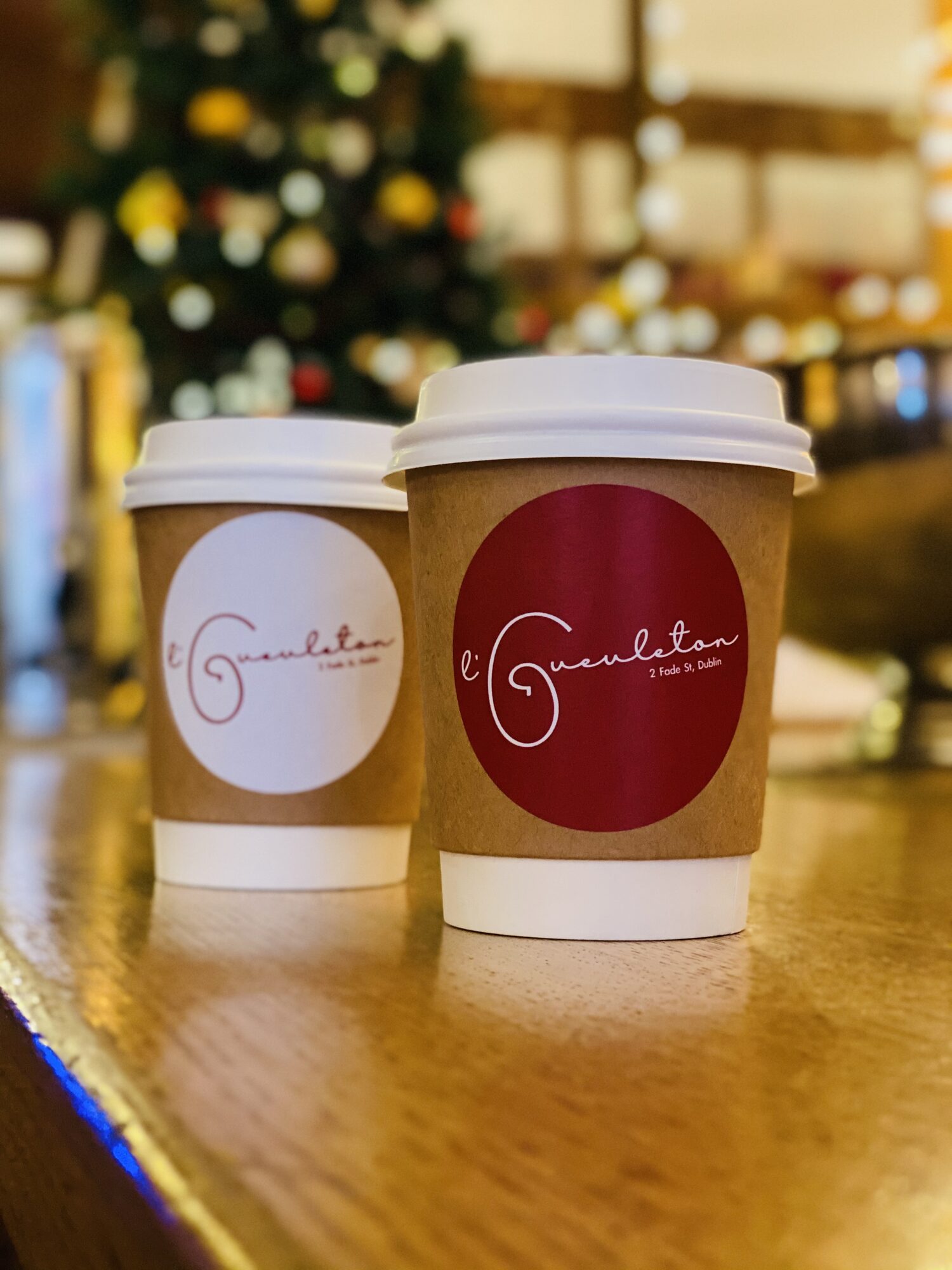 Coffee cups with red and white logo stickers.