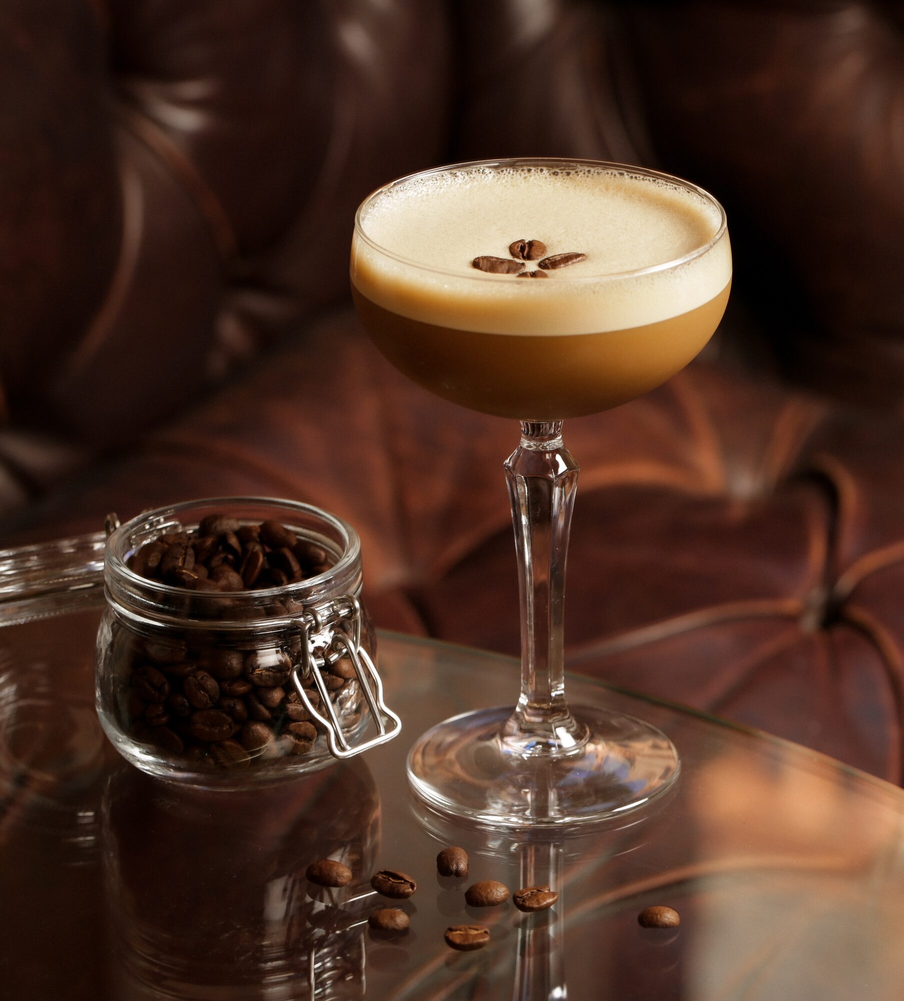 Espresso martini-style cocktail on a leather booth.