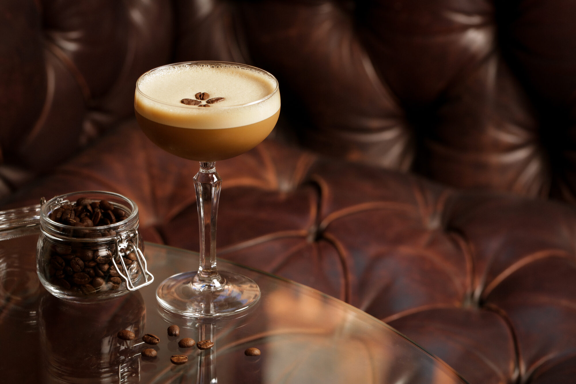 Cocktail in a leather booth — texture and atmosphere.