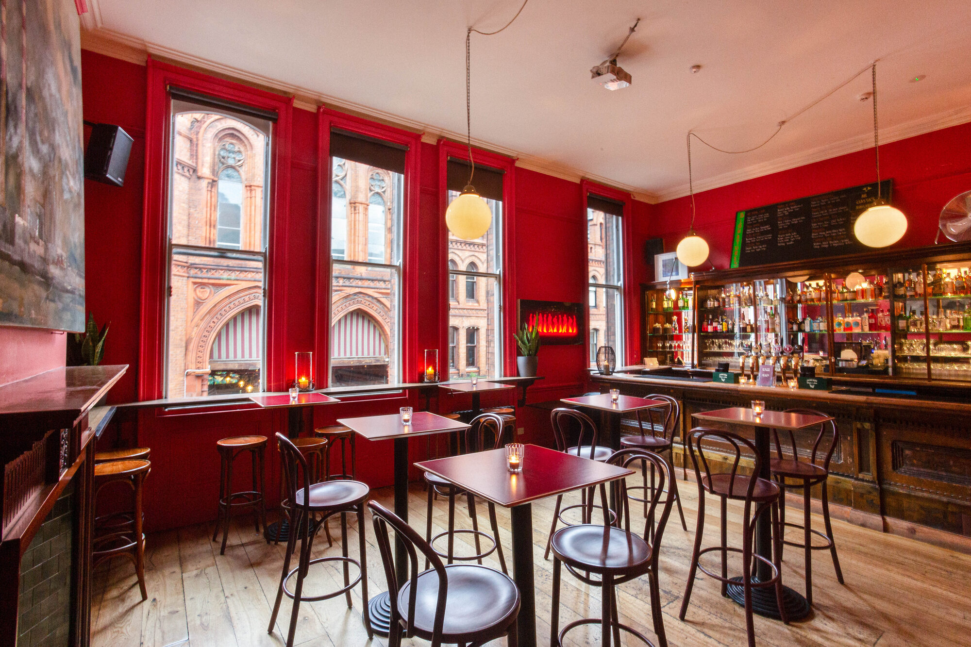The bar's red room — wide shot showing tables, windows and bar.
